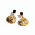 Gold shell-shaped earrings with black stones and pearl-like accents on a white background